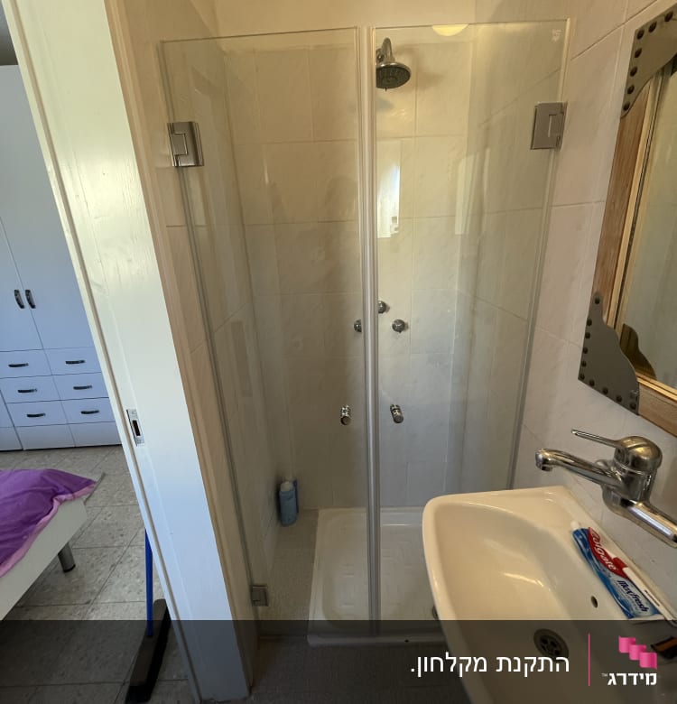 מקלחון זכוכית עם ראש מקלחת ובקבוק סבון